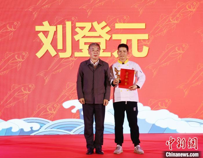 中国烹饪协会副会长乔杰(左)为2023全国大黄鱼美食烹饪大赛冠军颁奖。　林榕生 摄