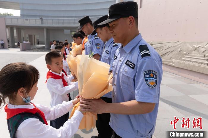 小学生给南京宪法公园的建设者、保安、保洁员代表献花。　陈向俞 摄